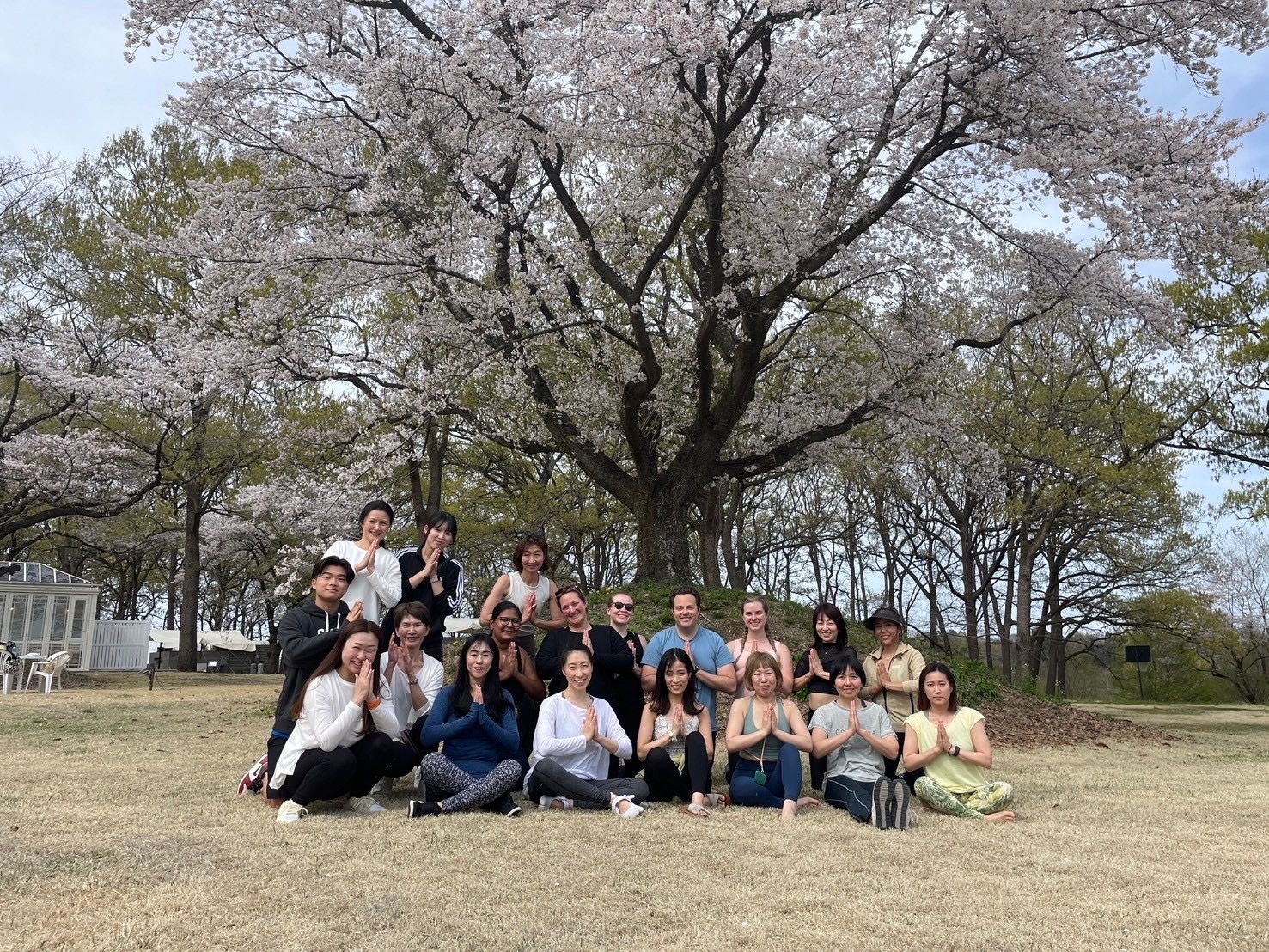 屋外ヨガイベントの参加者の集合写真